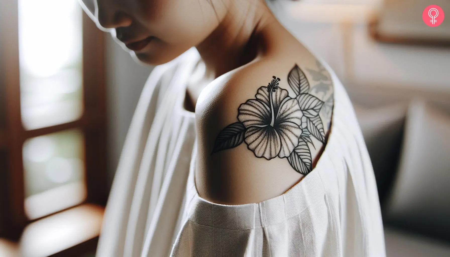 A fine line hibiscus tattoo on the shoulder