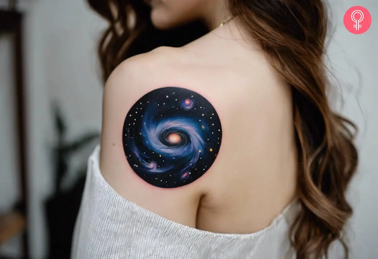 A woman with a galaxy black hole tattoo on her upper arm