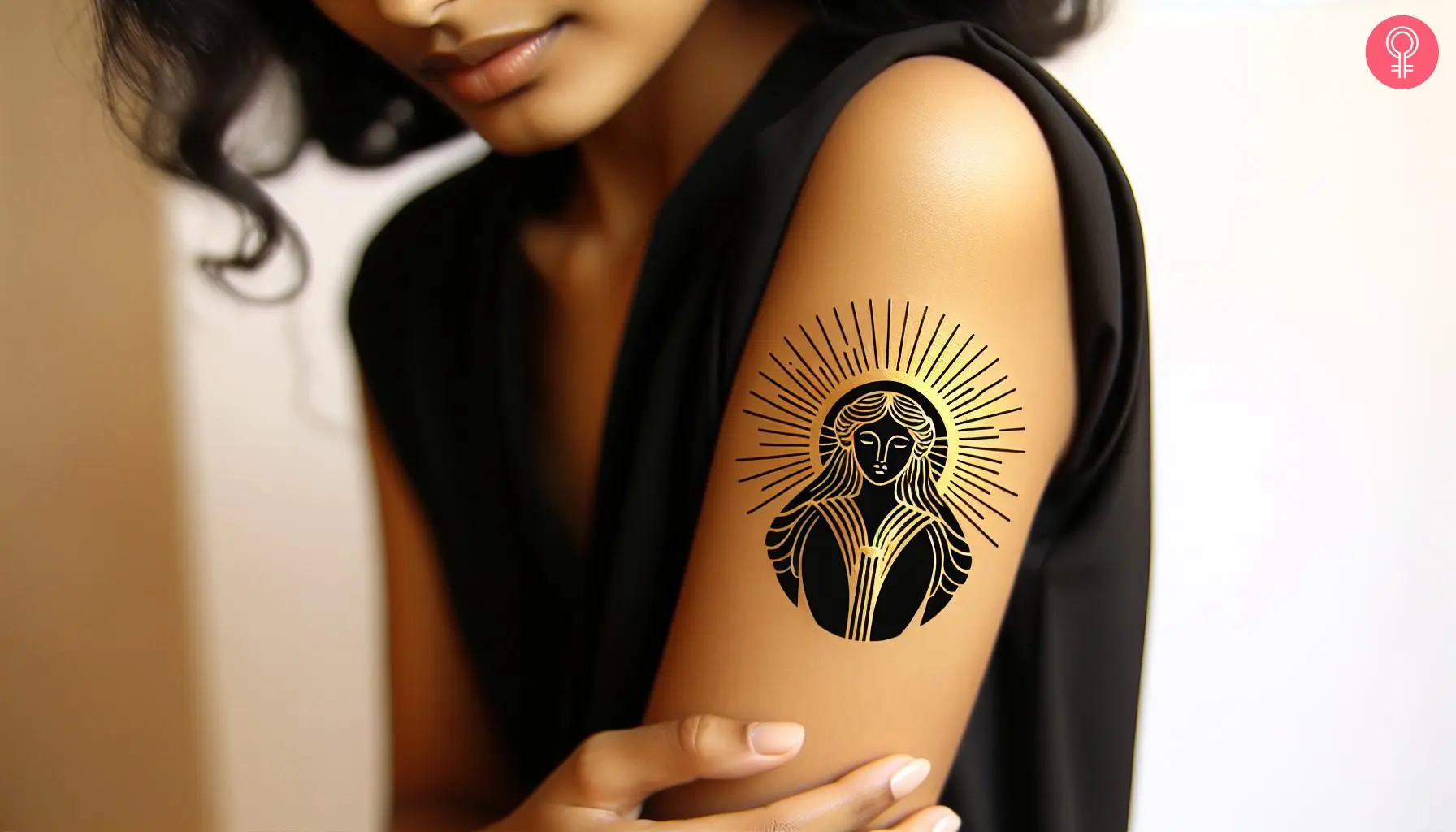 A woman with a golden and black Gaia tattoo on her upper arm