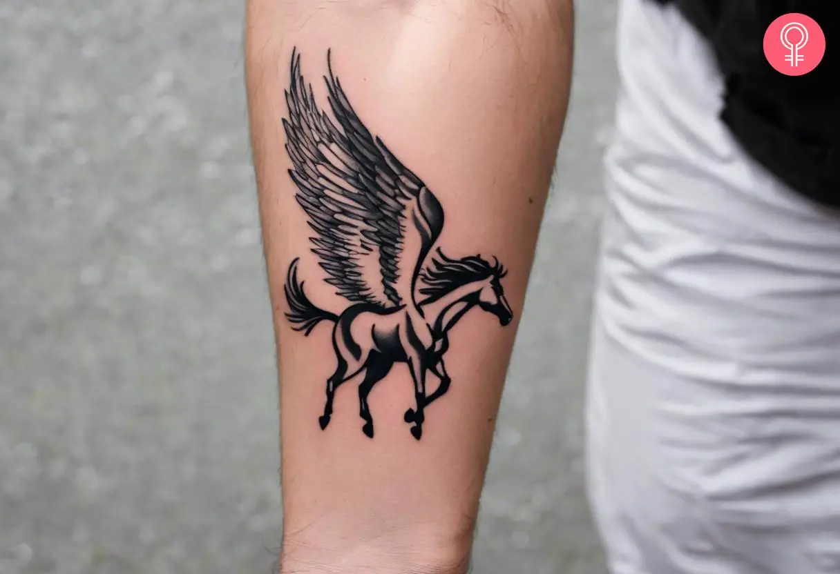 A black ink Pegasus tattoo on the forearm.