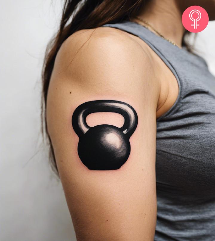 Black-and-grey kettlebell tattoo on the arm