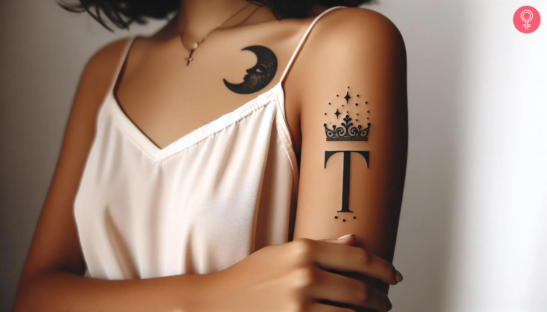 A woman wearing a tattoo of crowned ‘T’ letter on her upper arm