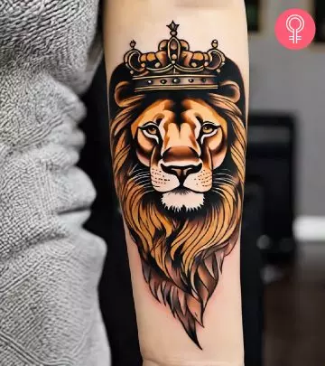 Lion head with crown tattoo on the forearm