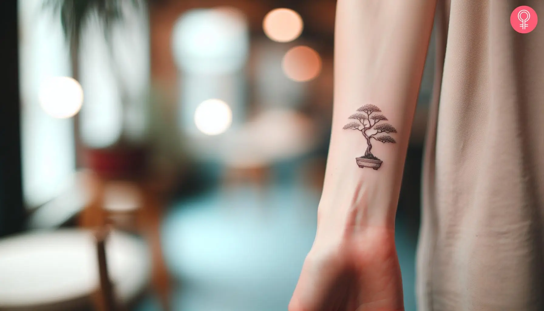 A woman with a minimalist bonsai tree tattoo on her wrist