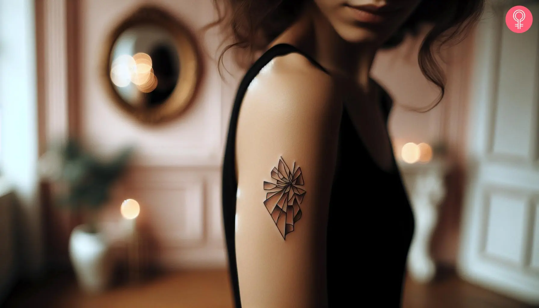 A woman with a minimalist broken glass tattoo on her upper arm