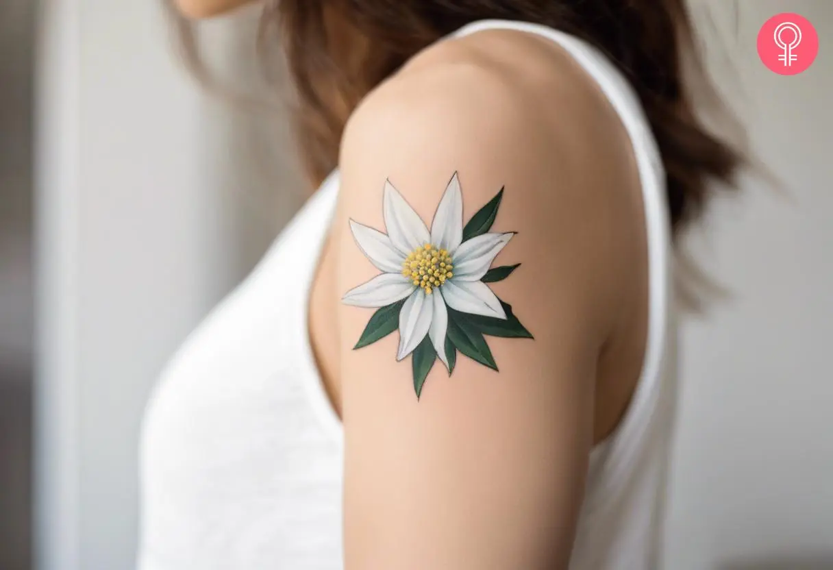 A woman with a minimalist Edelweiss flower tattoo on her upper arm