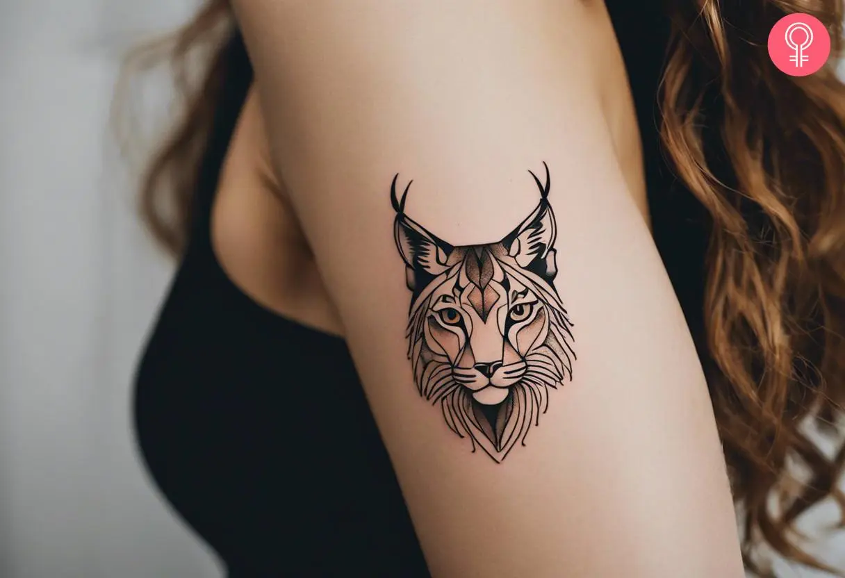 A small and minimalistic lynx tattoo on the upper arm