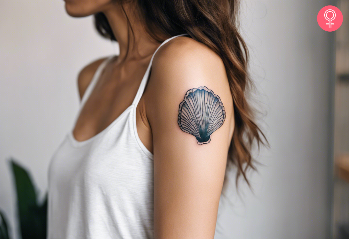 A woman with a minimalist oyster tattoo on her upper arm