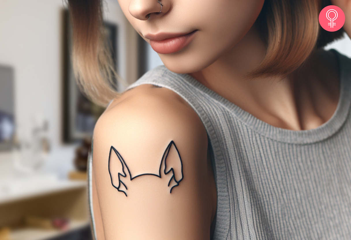 Minimalist dog ear outline tattoo on a woman’s arm