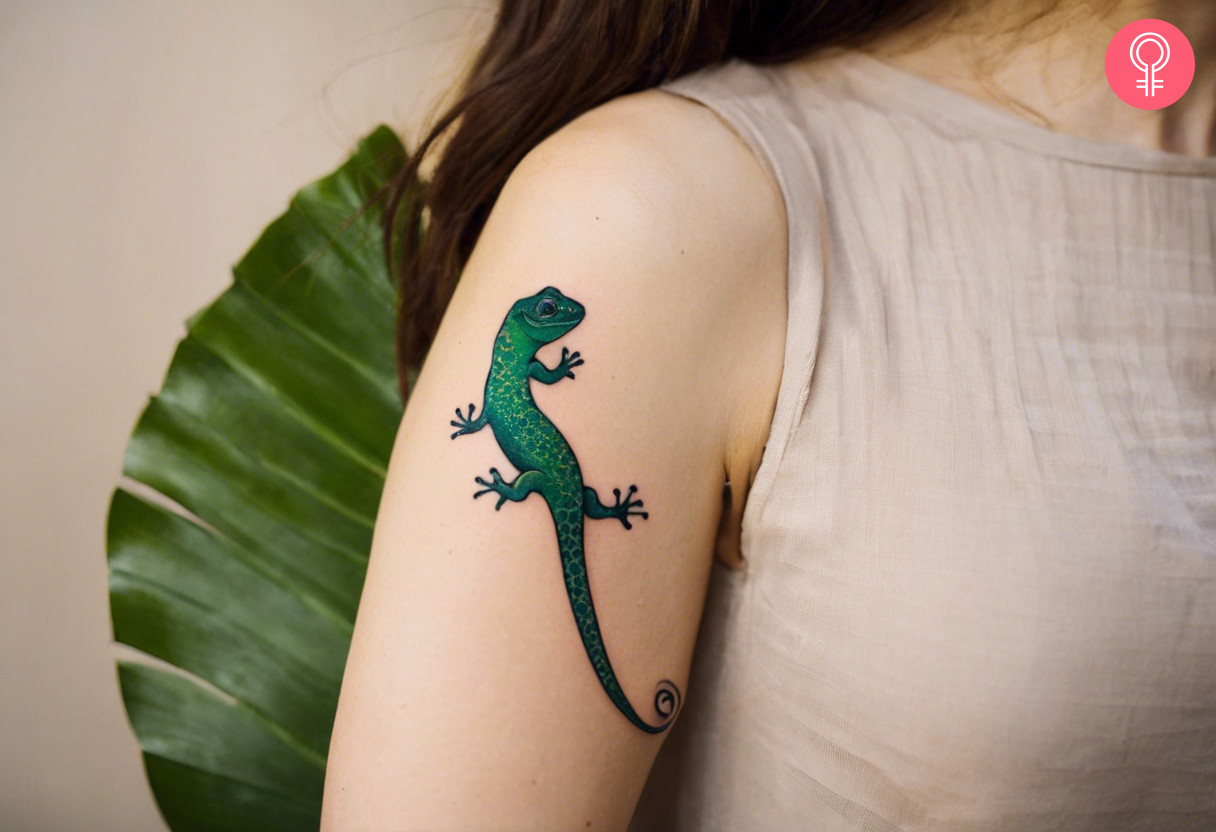 Minimalist gecko tattoo on a woman’s upper arm