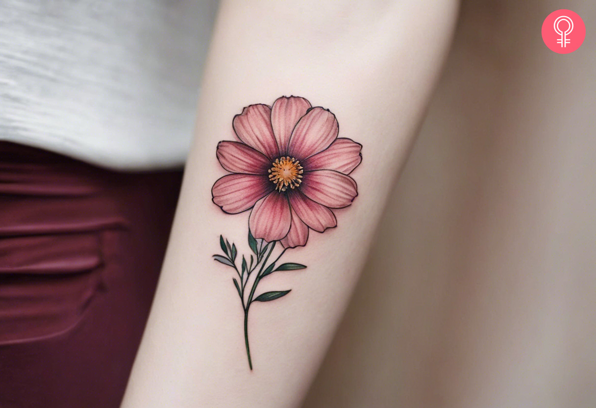 A minimalist cosmos flower inked on the forearm