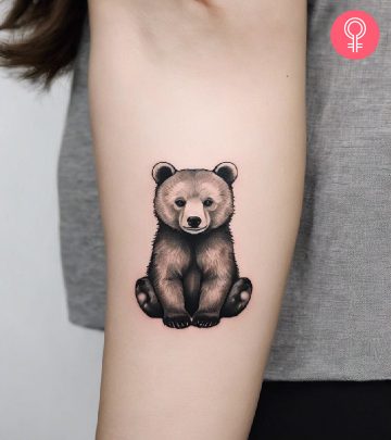 A woman with a bear and cub tattoo on her upper arm