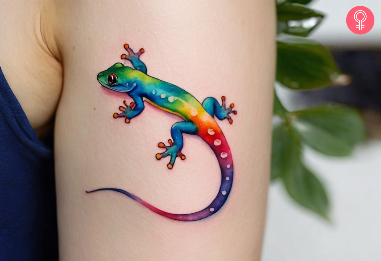 Rainbow colored gecko tattoo on a woman’s arm