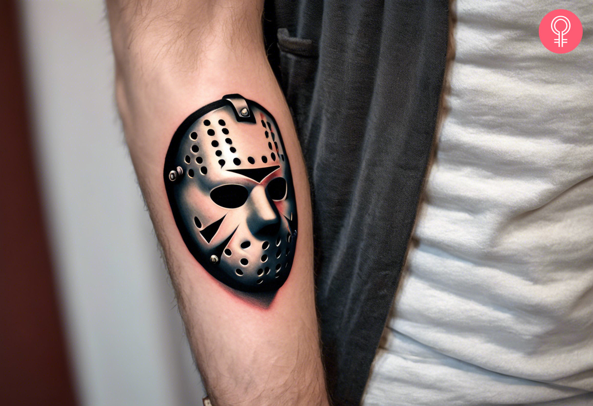 A realistic Jason mask tattoo inked on the forearm