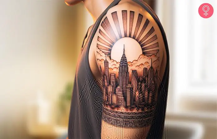 A man with a rising sun in skyline city tattoo on the upper arm.