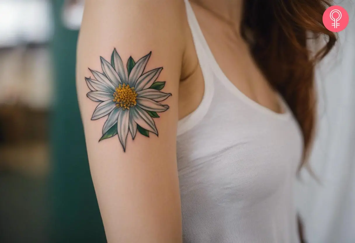 A woman with a traditional colored Edelweiss flower tattoo on her upper arm