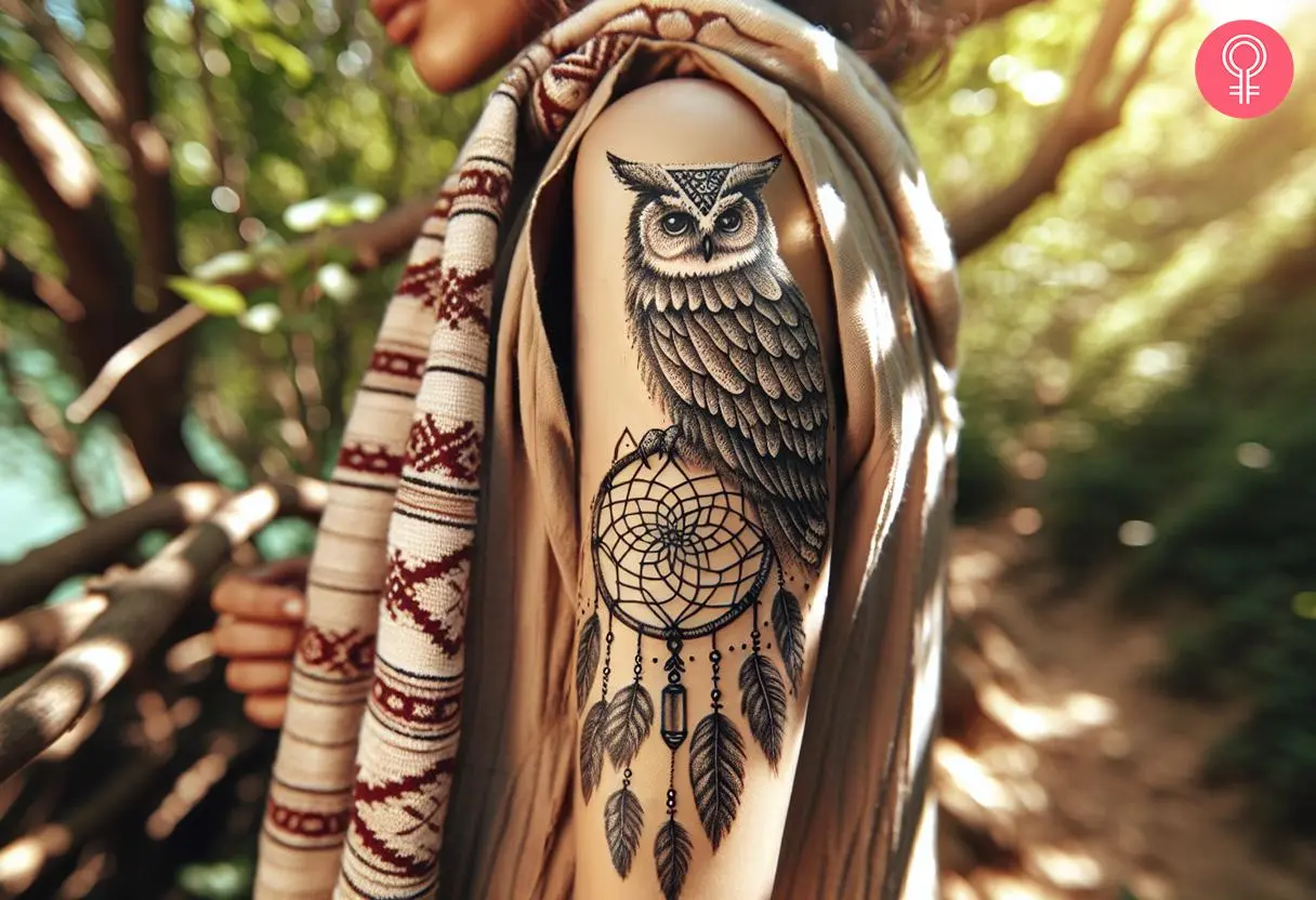 A woman with an owl and dream catcher tattoo on her upper arm