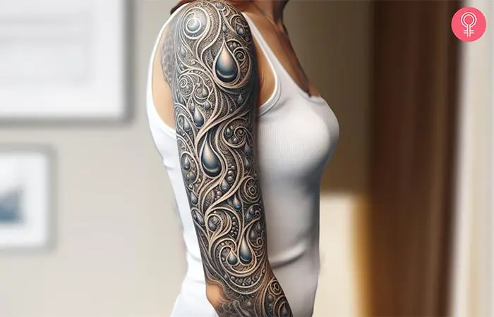 A woman with a colored water drop tattoo on her full sleeve