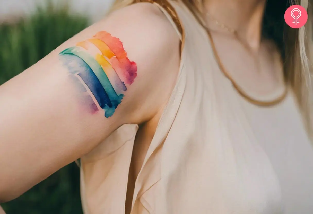 Watercolor rainbow tattoo on a woman’s arm