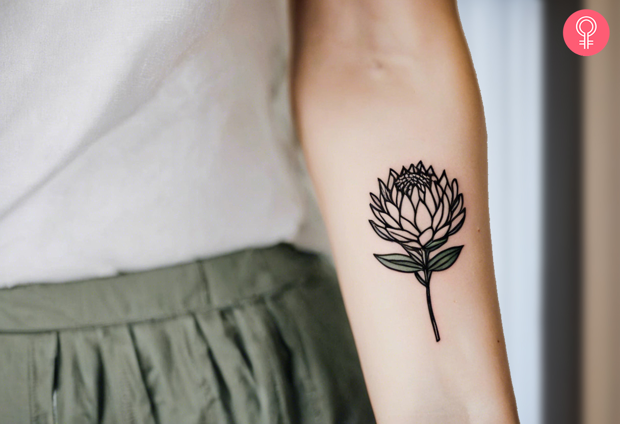 Woman with a queen protea tattoo inked on the forearm