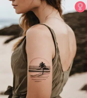 Woman with a tropical island tattoo on the upper arm