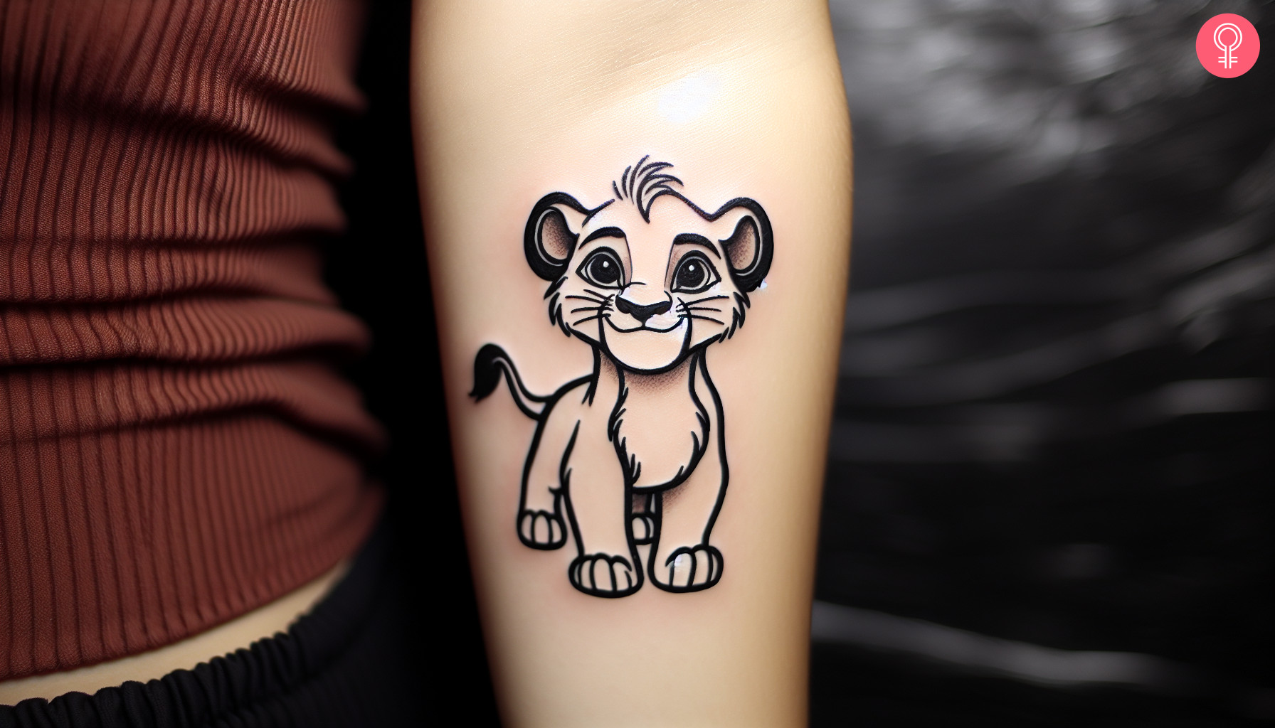 Woman with minimalist Simba tattoo on her arm