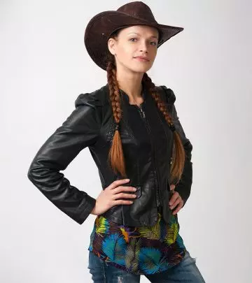 A woman with her reddish brown hair in pigtails with a cowboy hat.