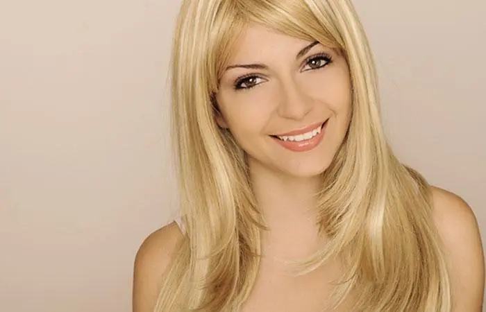 A blonde-haired woman with a layered hairstyle and a side part