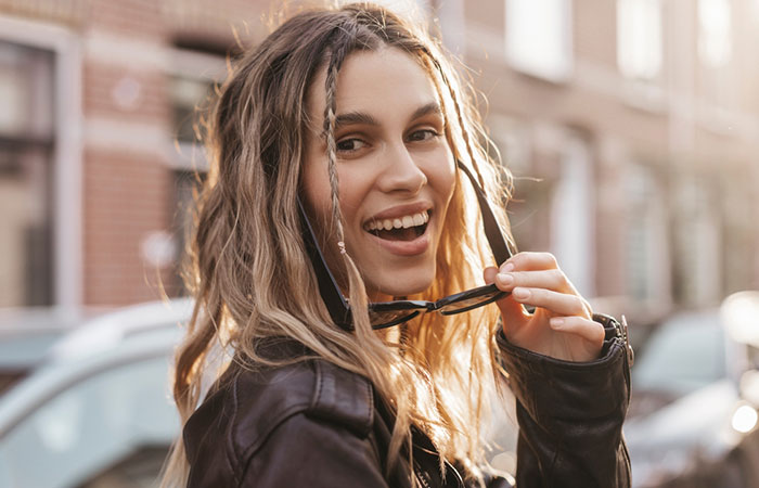 A close-up of a happy woman with a baddie rubber band hairstyle