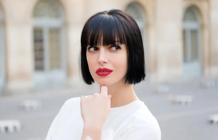 A woman sporting a short blunt bob hairstyle with bangs