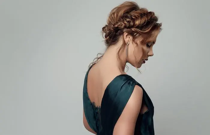 A woman with a messy crown braid and bun for homecoming