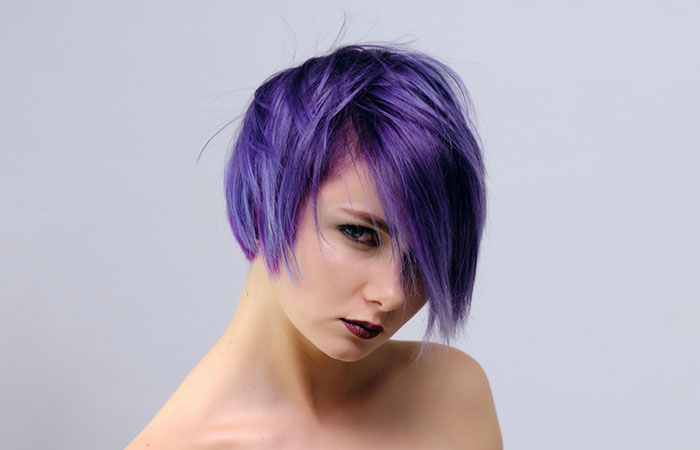 A woman with a vibrant purple long pixie haircut with bangs