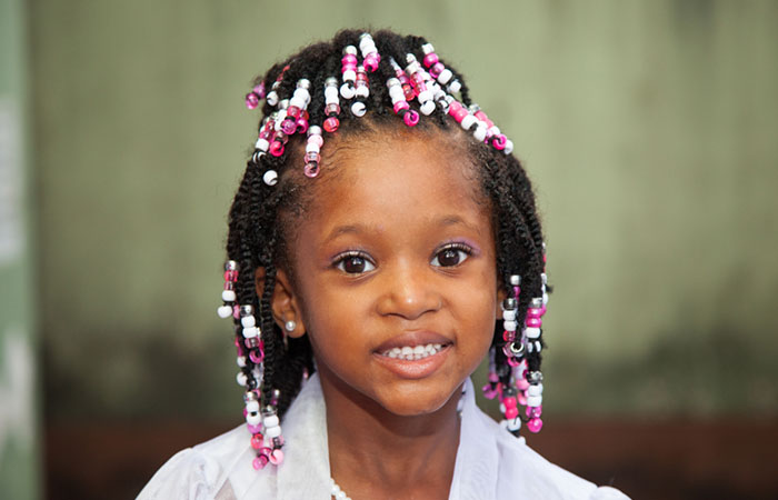 A kid with a flower girl hairstyle with braids