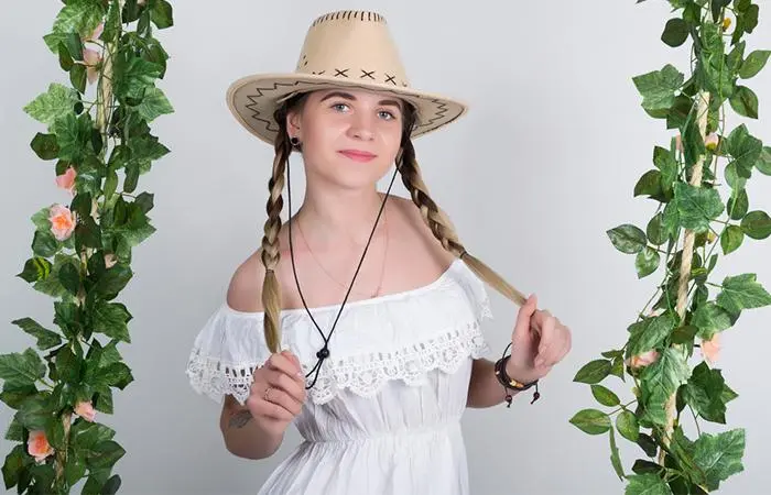 A young woman with blonde pigtails and a cowboy hat