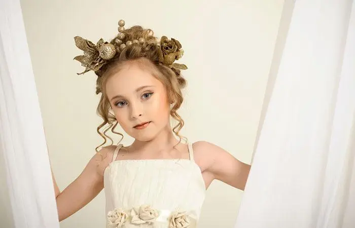 A kid with an elegant flower girl hairstyle