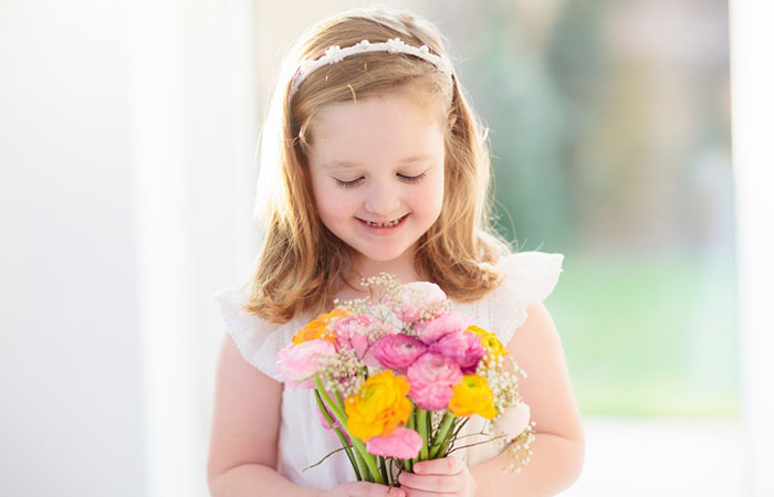 A kid with a flower girl hairstyle with a headband