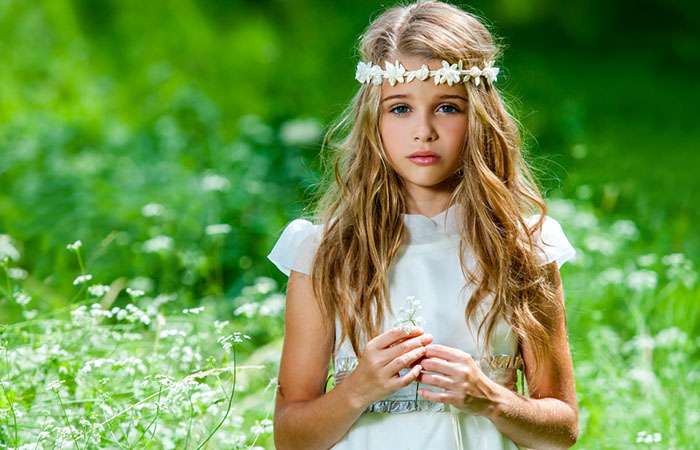 A kid with a long hair flower girl hairstyle