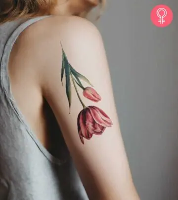 A colorful upside-down tulip tattoo on the upper arm