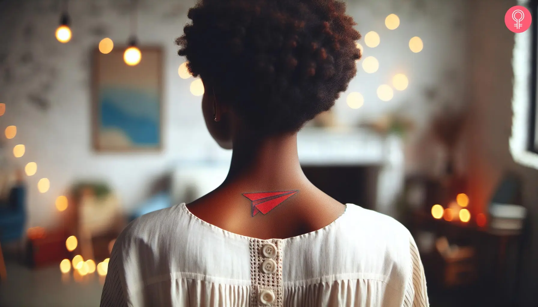 A red paper plane tattoo on the back of the neck