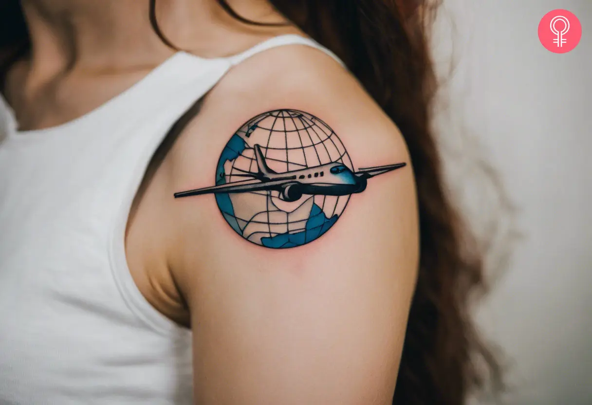 A shoulder cuff tattoo of a globe and a plane in the middle