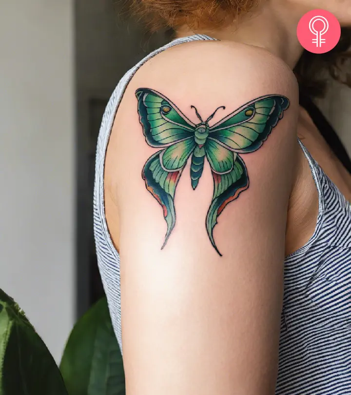 A woman with a vibrant luna moth tattoo on her upper arm