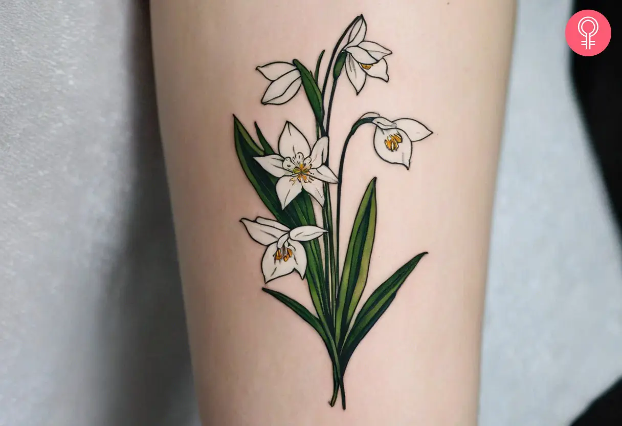 A woman wearing a ‘birth month flower bouquet’ tattoo on the lower arm.