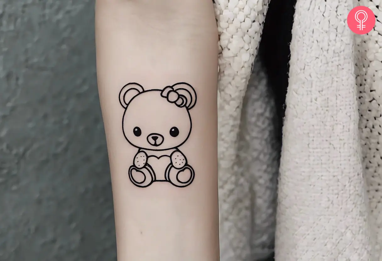 A Kawaii black-and-white teddy bear tattoo on a woman’s arm