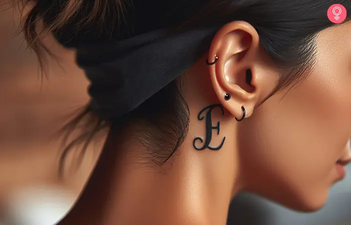 Letter E tattoo behind the ear