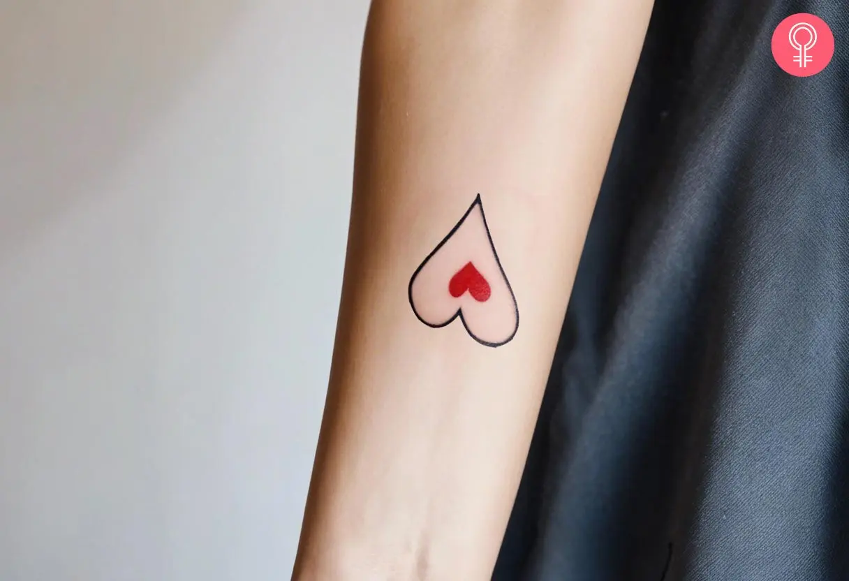 Upside down heart tattoo with a small red heart in a black ink heart