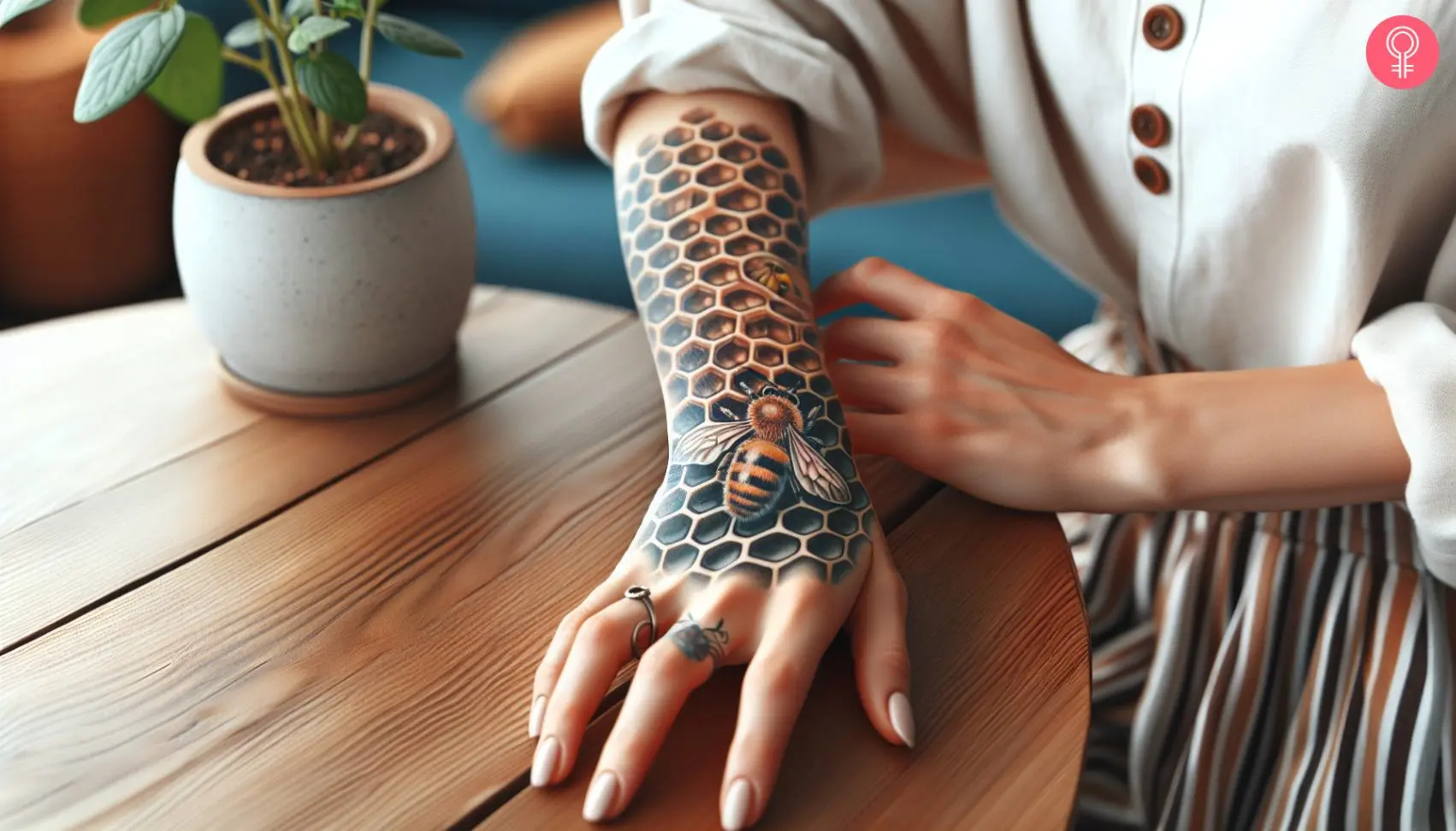 A woman with a honeycomb and bee tattoo on her forearm