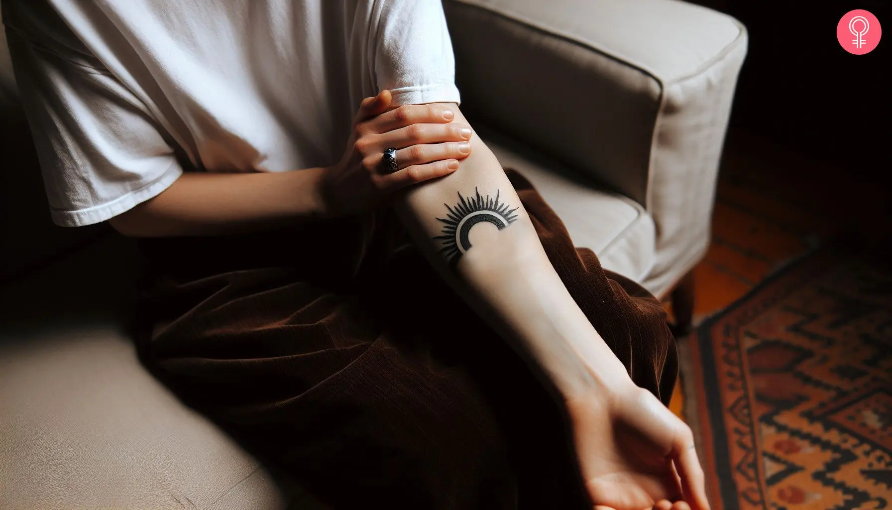 Semi-circular black sun tattoo on the forearm