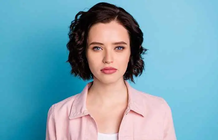 Woman with dark-colored wavy hair and pixie cut